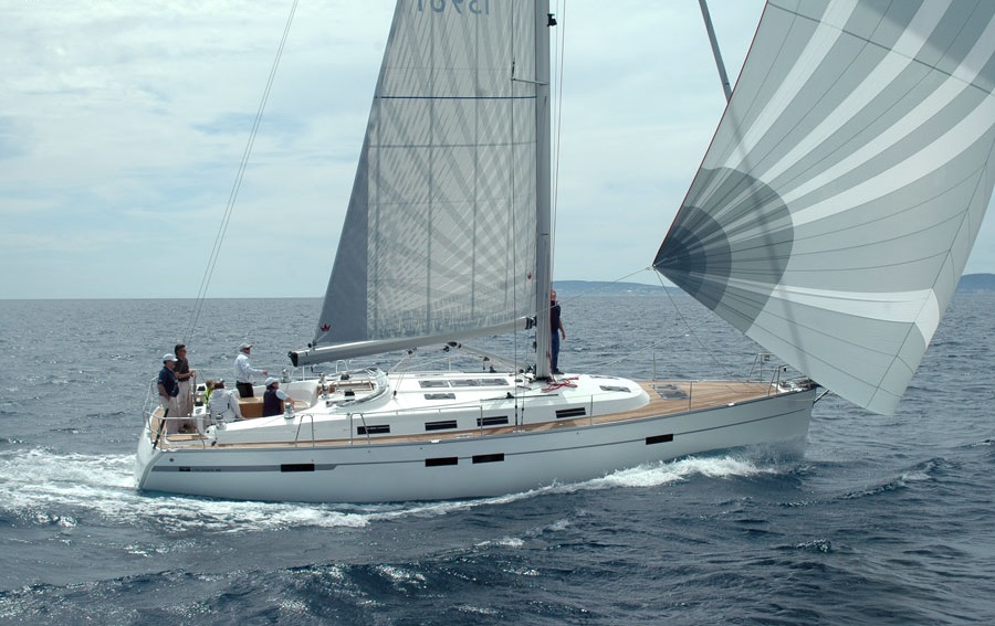 Segelyacht mit Spinnaker unter Segeln, Crew an Bord