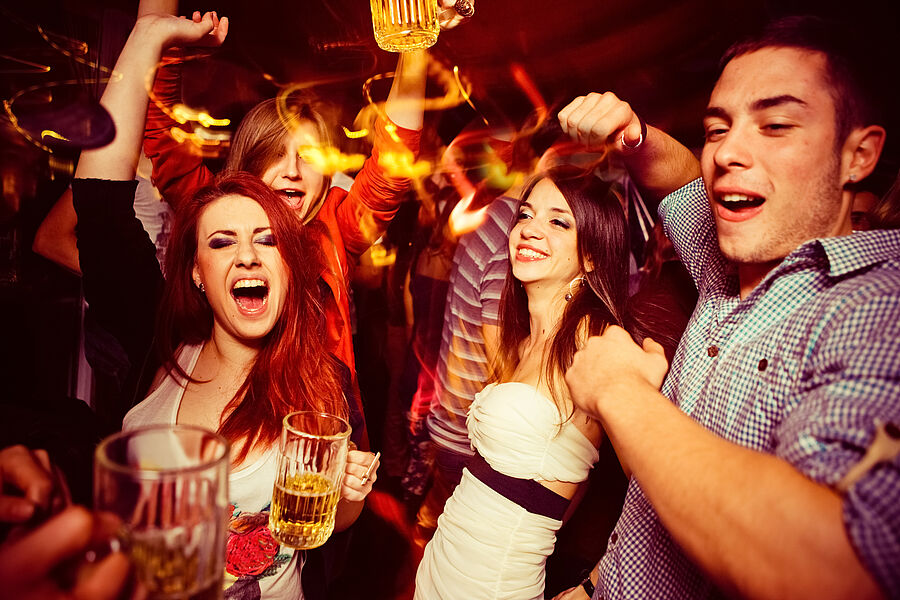 Ausgelassene Partystimmung in einem Club mit Biergläsern